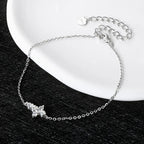 Silver bracelet with a butterfly charm on a black surface