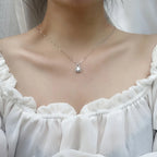 Necklace with a pendant worn by a person in a white top
