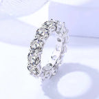 Silver ring with clear gemstones on a light purple background