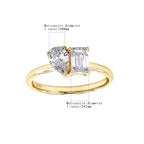 Gold ring with two moissanite stones on a white background