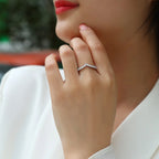 Close-up of a hand wearing a diamond ring with a blurred background