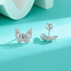 Butterfly-shaped silver earrings with gemstones on a turquoise background