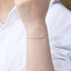 Silver bracelet on a person's wrist against a white background