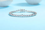 White gold bezel-set tennis bracelet with round brilliant stones on a soft blue background