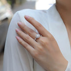 Hand wearing a diamond ring with a blurred background