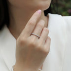 Close-up of a hand wearing a diamond ring with a blurred background