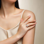 Woman wearing a diamond ring on her hand against a neutral background