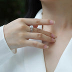 Close-up of a hand wearing a diamond ring with a blurred background