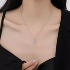 Necklace with a pendant worn by a person, focusing on the jewelry.