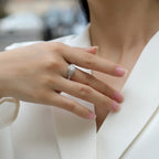 Close-up of a hand wearing a diamond ring with a blurred background