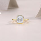 Gold ring with a large diamond on a light pink background
