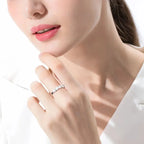 Close-up of a woman's hand wearing a diamond ring on a white background