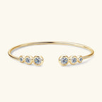 Gold bracelet with clear gemstones on a white background