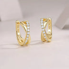 Gold hoop earrings with embedded diamonds on a light background