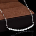 Silver necklace with clear stones on a brown and black background
