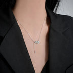 Necklace with a pendant worn by a person in a black blazer.