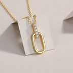 Gold necklace with a unique pendant on a beige card