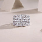 Silver ring with multiple rows of diamonds on a light background
