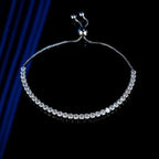 Silver bracelet with clear stones on a black background