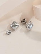 Pair of silver earrings with gemstones on a beige background