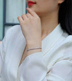 Close-up of a person wearing a silver bracelet on a blurred background