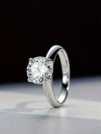 Silver ring with a diamond on a reflective surface