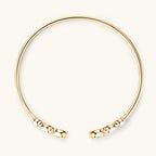 Gold bracelet with textured ends on a white background