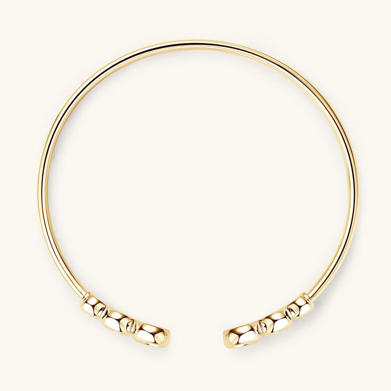 Gold bracelet with textured ends on a white background