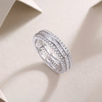 Silver ring with diamond accents on a light beige background
