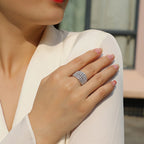 Close-up of a hand wearing a sparkling ring with a blurred background