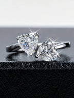 Two diamond rings on a black stand with a gray background