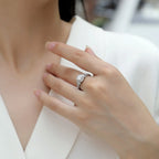 Close-up of a hand wearing a diamond ring on a blurred background