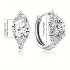Pair of silver earrings with clear gemstones on a white background