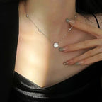 Necklace with a pendant worn by a person, with a hand touching the necklace.