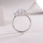 Silver ring with three diamond stones on a light pink background