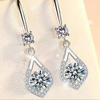 Silver earrings with clear gemstones on a soft background