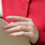Hand wearing a silver ring with a red shirt in the background