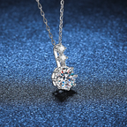 Silver necklace with a diamond pendant on a blue textured background