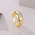 Gold ring with a diamond on a light gray background