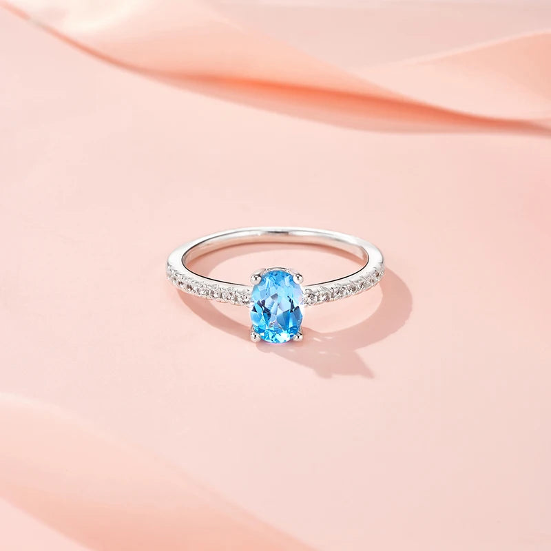 Ring with a blue gemstone on a soft pink background