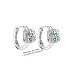 Silver hoop earrings with diamond-like stones on a white background