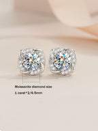 Pair of silver earrings with clear gemstones on a light background