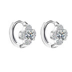 Pair of silver hoop earrings with clear gemstones on a white background