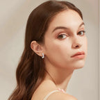 Close-up of a woman wearing a silver earring against a neutral background
