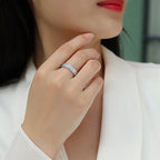 Close-up of a hand wearing a silver ring with a blurred background