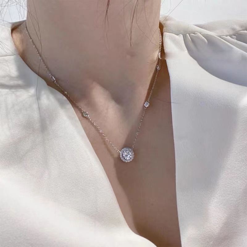 Delicate necklace with a small pendant on a light fabric background