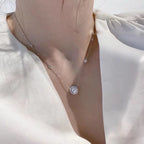 Delicate necklace with a small pendant on a light fabric background