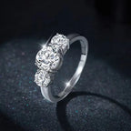 Silver ring with three diamonds on a dark background