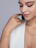 Model wearing a fine gold bracelet and minimalist gold necklace, styled in a refined studio portrait