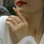 Close-up of a hand wearing a diamond ring with a blurred background